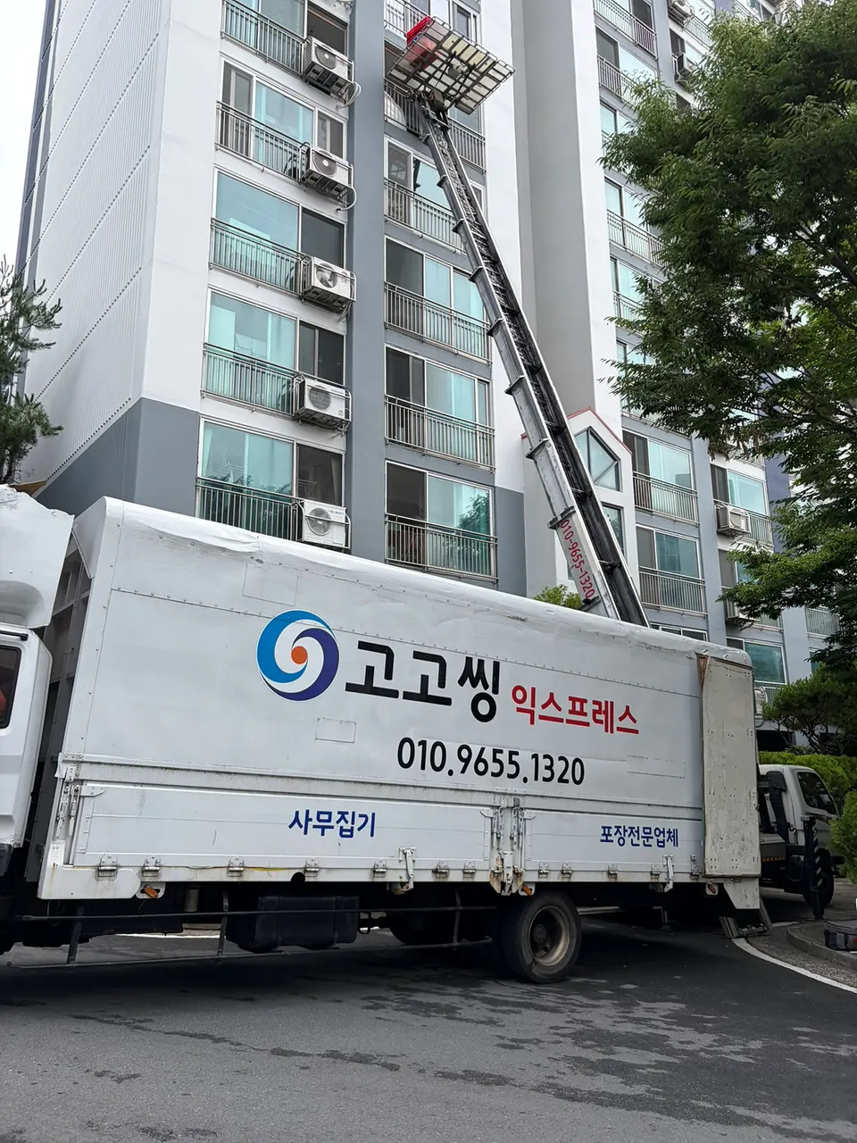 아파트 앞에 선 고고씽익스프레스 트럭과 사다리차